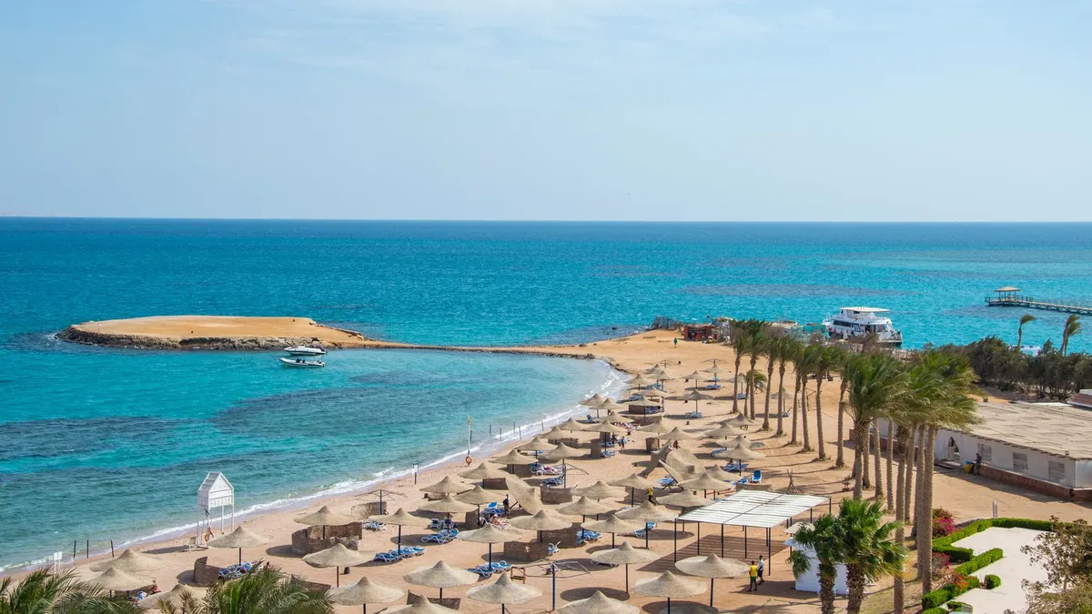 Strand met parasols en helderblauw water aan de Rode Zee bij Hurghada in Egypte