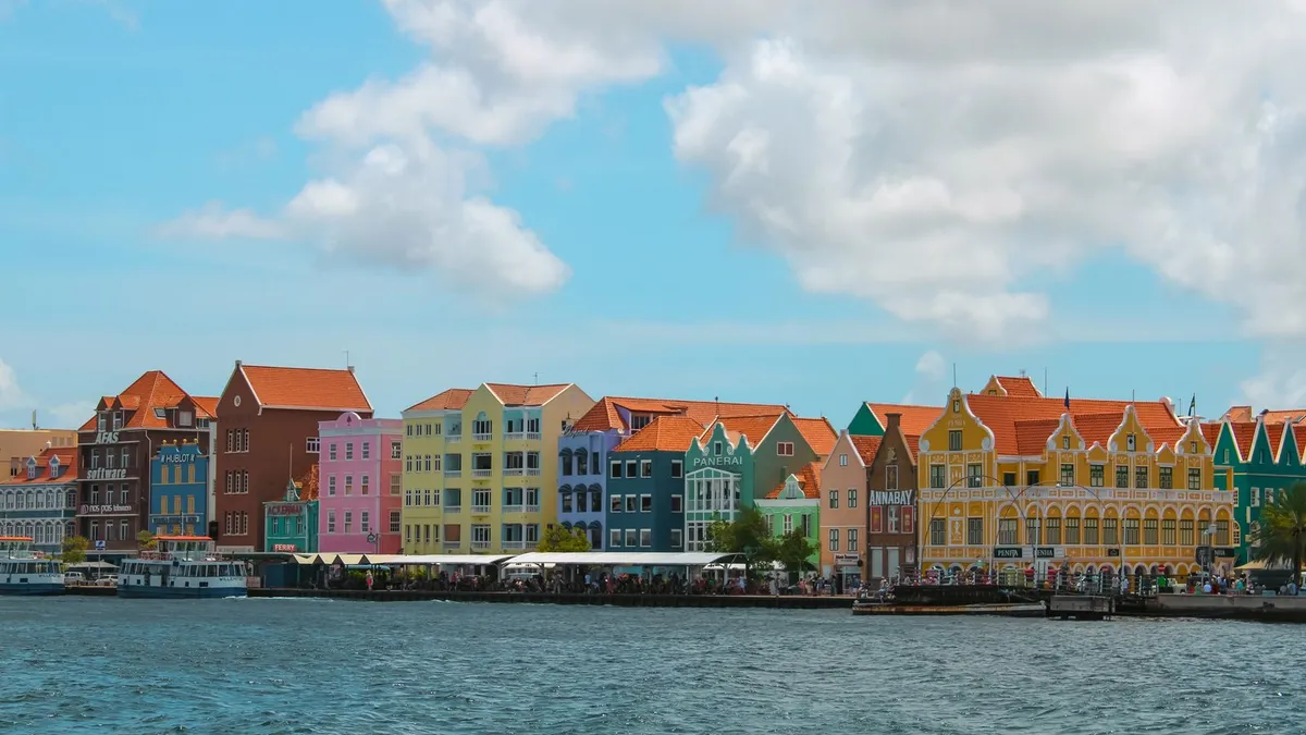 Kleurrijke historische gevels aan de Handelskade in Willemstad op Curaçao, gezien vanaf het water